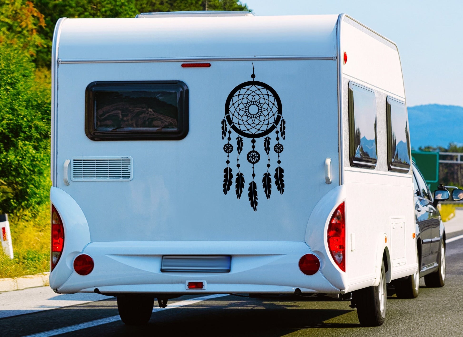 a large boho style dreamcatcher stuck on to a caravan